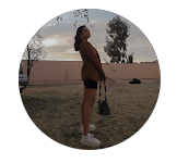 Mujer de pie en un jardín al atardecer, ideal para promocionar paneles solares industriales sostenibles y eficientes en entornos residenciales y empresariales.